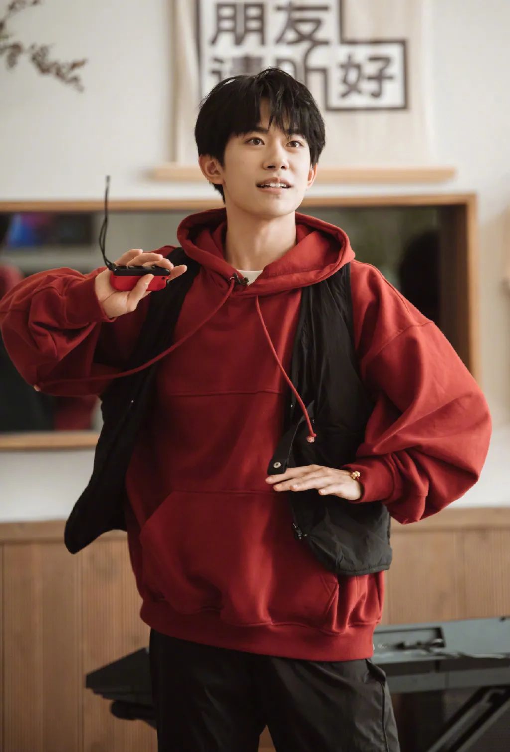 易烊千玺不仅用白t内搭枣红色连帽卫衣,还在外面套上了一件黑色马甲
